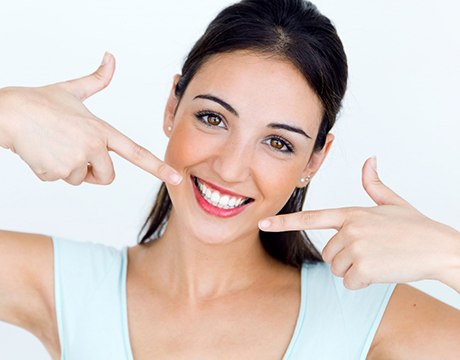 woman pointing to her smile after getting dental bonding in Gainesville 