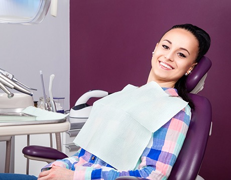 Dental patient in patterned shirt leaning back and smiling