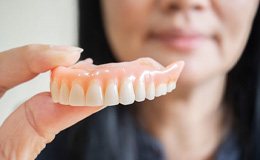 a woman in Gainesville holding a set of dentures