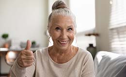 Older woman with dentures in Gainesville giving a thumbs up