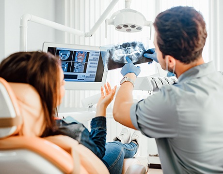 a dentist showing a patient her X-rays