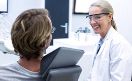 Dentist explaining cost of dental implants in Gainesville to patient