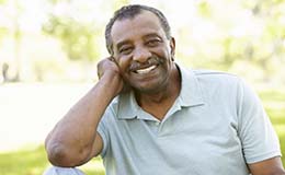 man in a green polo shirt sitting in a park