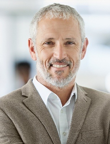 Older man smiling and wearing suit