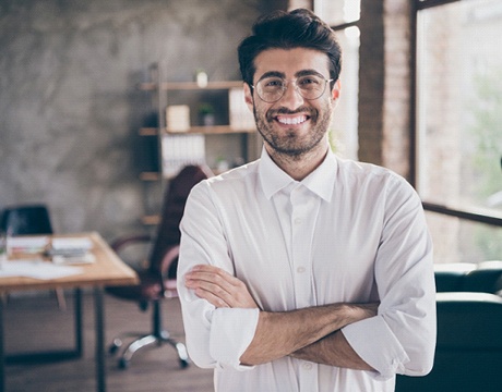 person smiling with their arms crossed