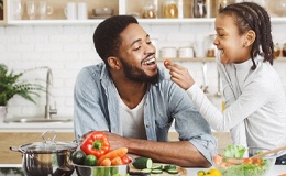 child giving their dad a cherry tomato