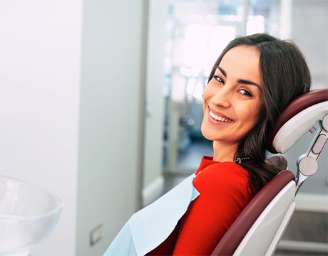 Smiling dental patient in a red shirt after seeing a sedation dentist in Gainesville