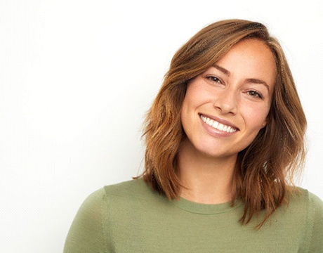 Beautiful woman in green shirt, smiling with veneers