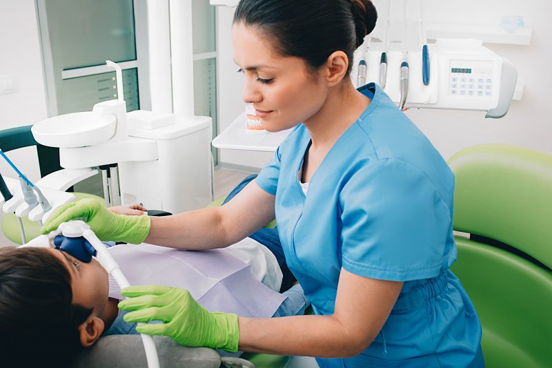 Dentist putting nitrous oxide nose piece on patient