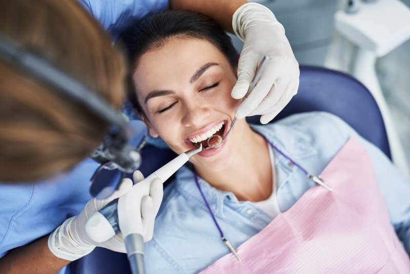 a female patient having her teeth checked and cleaned during a regular visit 