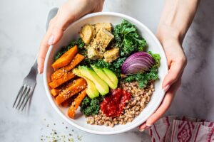 Birds eye view of hands holding a salad over a marble counter