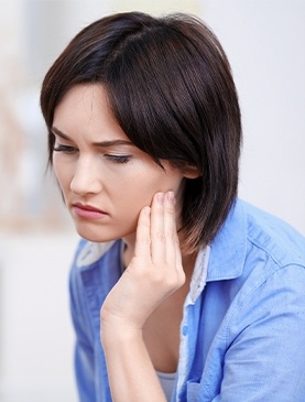 Woman in pain holding cheek